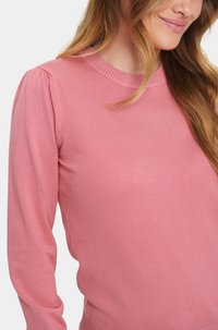 Rosa pullovertröja med ribbad rund halsringning och puffärmar. Slät, strukturerad tyg med en figurnära silhuett.