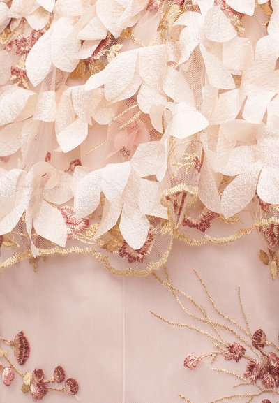 Ανοιχτό ροζ ύφασμα με στρωματοποιημένες λευκές παιωνίες εφαρμογές και χρυσές και σκόπελες τριανταφυλλένιες λουλουδένιες κεντήματα.