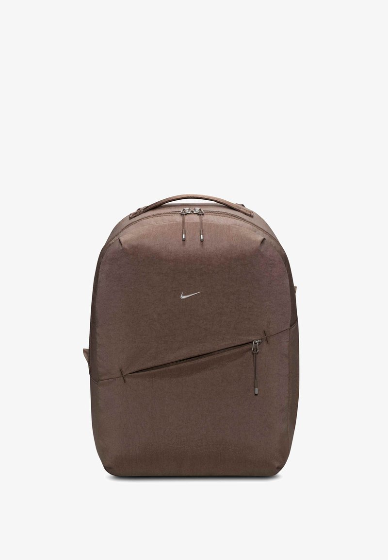 Brūns neilona mugursoma ar teksturētu virsmu, divām rāvējslēdzēju augšdaļām, priekšējo rāvējslēdzēju kabatu un mazu sudraba Nike logotipu priekšpusē.