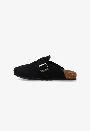 Zwarte suède instapslof met verstelbare zilveren gesp en kurken voetbed, weergegeven op een witte achtergrond, zijaanzicht.