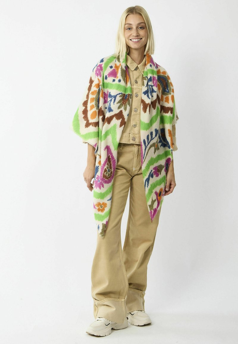 Kleurrijke sjaal met groene, oranje, roze en blauwe bloemenpatronen op een crèmekleurige basis. Draag het over een beige blouse met knopen en een broek.