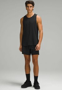 Ensemble débardeur noir et short, fabriqué en tissu léger. Le débardeur a une encolure ronde, et le short possède une taille élastique et des poches latérales.