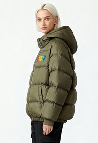 Veste matelassée vert olive avec capuche, ornée d'une broderie multicolore "AMOUR" sur la poitrine, manches à poignets élastiques et fermeture éclair.