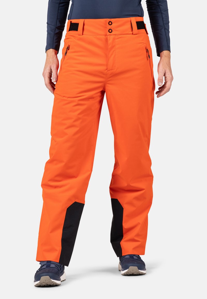 Orangene wasserdichte Skihosen mit geradem Beinschnitt, schwarzen Akzenten am Saum, zwei vorderen Reißverschlusstaschen und verstellbarem Bund.