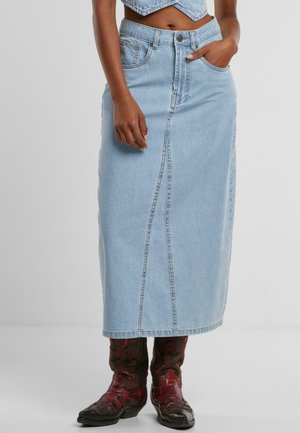 Hellblauer Jeansrock, knielang, mit vorderer Nahtverarbeitung, Gürtelschlaufen und zwei Seitentaschen. Kombiniert mit roten gemusterten Stiefeln.