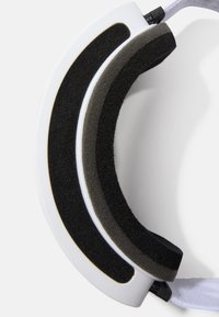 Los auriculares blancos presentan una almohadilla de espuma negra acolchada con una superficie suave y un diseño curvado, que contrasta con una correa negra y hardware ajustable.