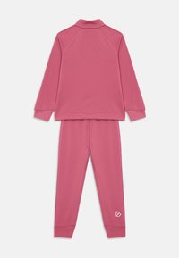 Ensemble de survêtement rose pour enfants en deux pièces, avec des manches longues, un pantalon long, des poignets côtelés et un petit logo sur la cuisse gauche.