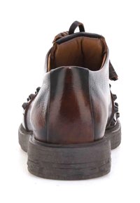 Brązowy skórzany botek za kostkę z okrągłym noskiem, charakteryzujący się fakturowaną powierzchnią i solidną czarną gumową podeszwą. Widok z tyłu ukazuje detale sznurowania.