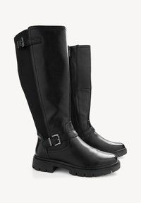 Botas negras hasta la rodilla con acabado de cuero brillante, cremallera lateral y hebillas ajustables en la parte superior. Suelas de goma resistentes para mayor tracción.
