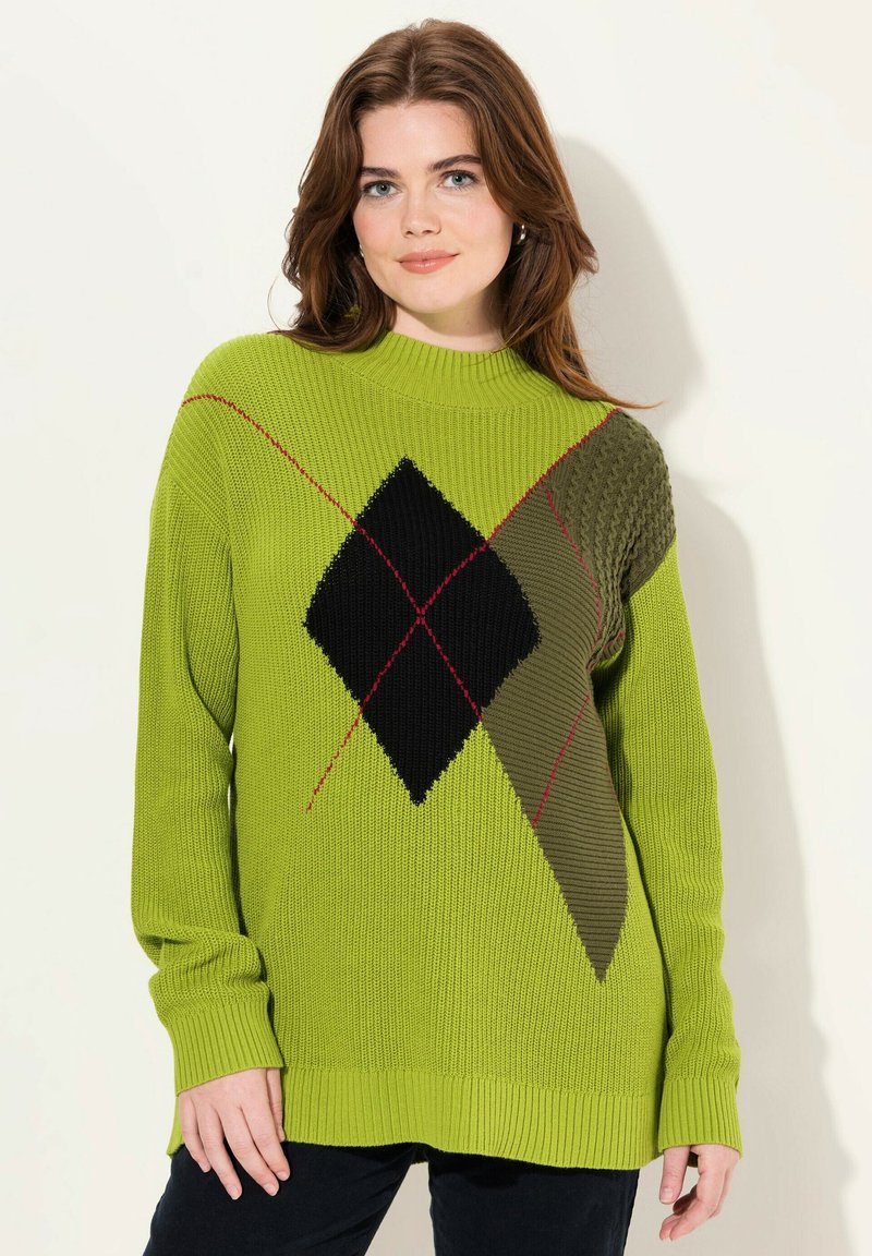Pull en tricot vert avec un motif géométrique comprenant un losange noir et des accents texturés. Les poignets et l'ourlet côtelés améliorent l'ajustement et le style.