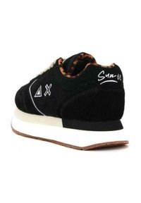 Sneaker in suede nero con accenti bianchi, caratterizzato da una fodera con stampa leopardata, una larga suola intermedia bianca e una suola in gomma. Branding ricamato sul tallone.