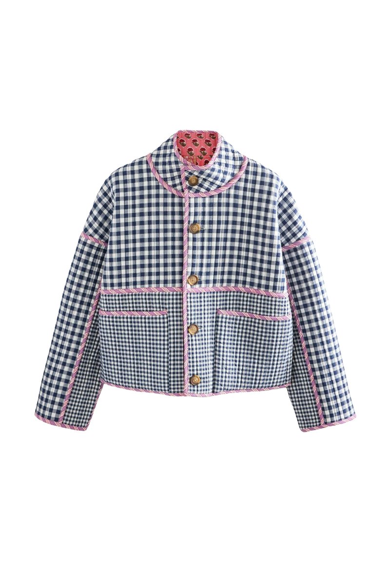 Veste à carreaux bleue et blanche avec bordure rose, boutons en bois, deux poches avant et doublure intérieure fleurie au col.