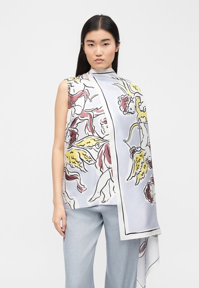 Γυναίκα που φοράει αμάνικο τοπ με μεγάλο, ασύμμετρο κασκόλ που έχει πολύχρωμα, εικονογραφημένα αγγελούδια με τόξα και φτερά, συνδυασμένο με ανοιχτό κυανό παντελόνι.