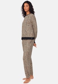 Conjunto de lounge con estampado de leopardo en tela suave. Top de manga larga con ribete negro, pantalones elásticos a juego. Corte relajado, ligero y transpirable.