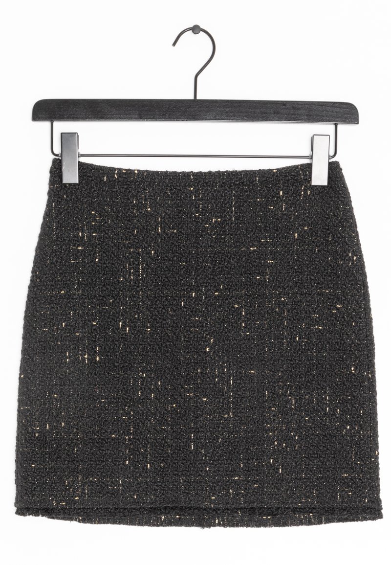 Jupe en tweed noir avec des accents de fil métallique. Design court et ajusté avec une surface texturée. Pend sur un cintre noir et fin.