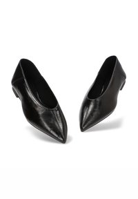 Un par de zapatos de mujer de cuero negro, con punta afilada y tacón bajo, sobre un fondo blanco.