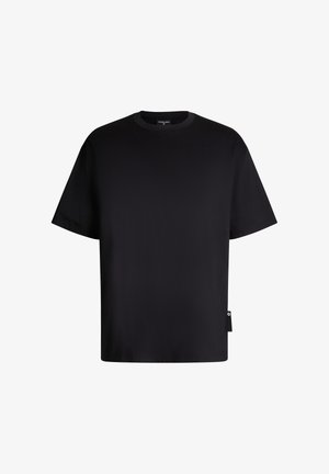 Schwarzes Baumwoll-T-Shirt mit rundem Halsausschnitt, kurzen Ärmeln und lockerer Passform. Enthält ein kleines Logotag auf der linken Seite.