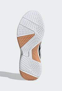Schuhsohle aus strukturiertem weißem Gummi mit orangefarbenen Akzenten und schwarzen Designelementen. Verfügt über hexagonale und kreisförmige Griffmuster für besseren Halt.
