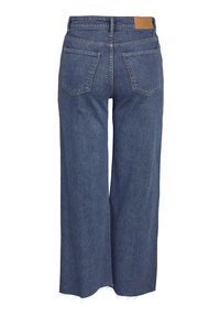 Μπλε τζιν παντελόνι με φαρδιά πόδια και σκισμένα τελειώματα, δύο πίσω τσέπες, βολάν για ζώνη και καφέ δερμάτινη ετικέτα μάρκας στη μέση.