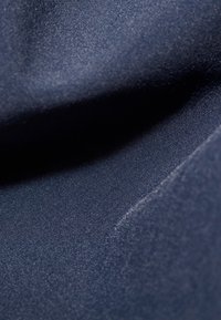 Ciemnoniebieska tkanina o gładkiej, lekko błyszczącej fakturze, prezentująca miękki spływ i subtelny połysk. Brak wzor ów lub wyraźnych elementów metalowych.