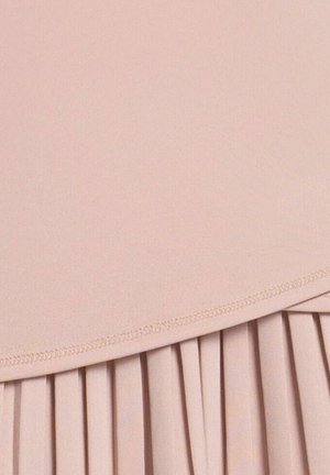 Tela de color rosa suave con una sección superior lisa y una sección inferior plisada separadas por una costura curva cosida.