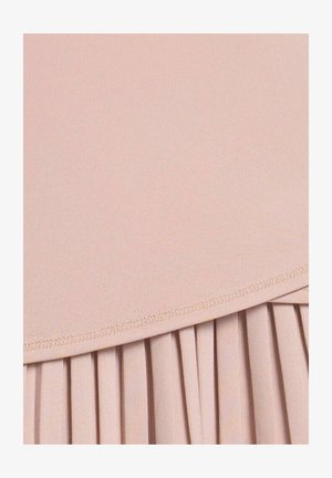 Tela de color rosa suave con una sección superior lisa y una sección inferior plisada separadas por una costura curva cosida.