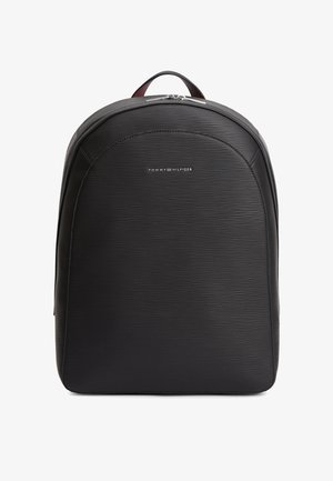 Black textured backpack with zip closure and small Tommy Hilfiger logo on front, shown against a plain white background.