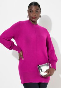 Magenta Strickpullover mit Puffärmeln und gewelltem Saum, kombiniert mit einer silbernen Umhängetasche. Glatte Textur, lässige Passform.