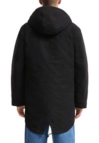 Zwarte gewatteerde parka met een lengte tot halverwege de bovenbenen, voorzien van een trekkoord aan de onderkant en een soepele, matte afwerking. Heeft zijzakken.