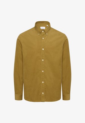 Dzeltenbrūnas pogas krekls, kas izgatavots no teksturētas auduma. Tam ir izklāta apkakle un vertikālas svītras. Garas piedurknes ar pogu aprocēm.