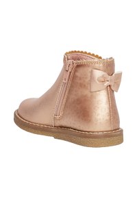 Botín para niños en color rosa dorado, con cremallera lateral, parte superior texturizada, lazo decorativo en el talón y suela de goma.