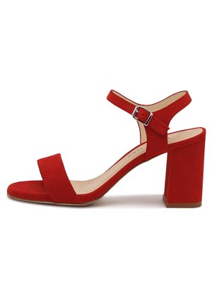 Czerwona zamszowa sandałka na wysokim obcasie typu blok z odkrytymi palcami, szerokim paskiem z przodu zapewniającym wsparcie oraz paskiem wokół kostki z klamrą.