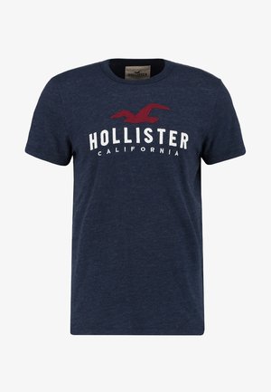 Granatowy T-shirt z krótkim rękawem z czerwonym logo ptaka i białym napisem "Hollister California" na piersi.