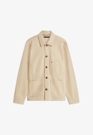 Giacca in tela beige con scollo con colletto, chiusura frontale con bottoni, due grandi tasche anteriori e una piccola tasca sul petto.