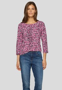 Long-sleeve top in a multicolored pink and black abstract pattern, made of a smooth fabric. Features a rounded neckline and relaxed fit.