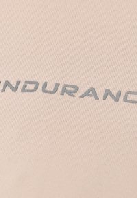 Helles beiges, geripptes Gewebe mit dem Wort "ENDURANCE" in grauen, strukturierten Buchstaben. Glatte Textur mit subtiler Schattierung.
