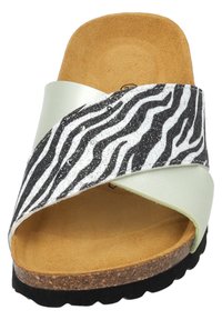 Witte en zwarte zebra-gestreepte schuif sandaal met een kurken voetbed, met een metallic afwerking op de bovenste strap en een gestructureerd oppervlak.