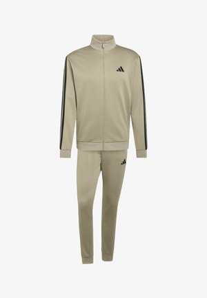 Chándal beige de Adidas con chaqueta de cremallera completa y pantalones a juego, con rayas negras en las mangas y logo de Adidas en el pecho y el muslo.