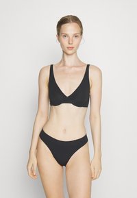 Black bikini set featuring a V-neck bra with wide straps and a matching low-rise bottom, both made from smooth, stretchy fabric.