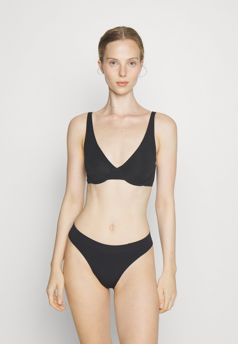 Black bikini set featuring a V-neck bra with wide straps and a matching low-rise bottom, both made from smooth, stretchy fabric.