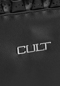 Pelle nera testurizzata con un lucido logo argento "CULT". Il design presenta un dettaglio arricciato lungo il bordo superiore.