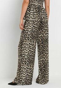 Pantaloni wide-leg con stampa leopardata, realizzati in un tessuto leggero, nei colori nero e tan, e dal design rilassato con vita alta.