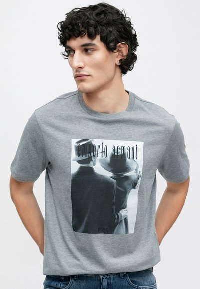 Γκρι βαμβακερό μπλουζάκι με κοντά μανίκια που διαθέτει ασπρόμαυρο γραφικό σχέδιο δύο φιγούρων που φορούν καπέλα, με την επισήμανση "Emporio Armani".