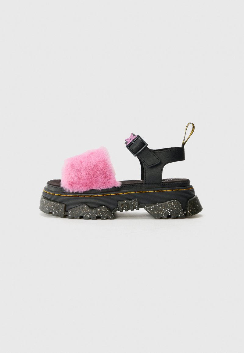 Kraftige svarte sandaler med rosa kunstpels på toppen, justerbar stropp og spraglete teksturert såle. Har gult søm og en løftripe.