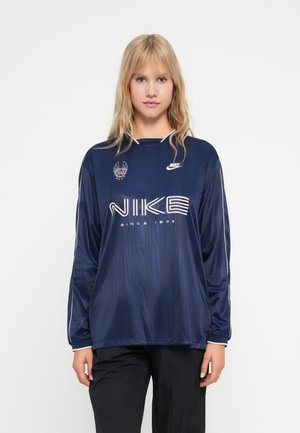 Marineblaues, langärmeliges Nike-Shirt mit Rundhalsausschnitt, weißem Logo und gestreiften Akzenten an den Ärmeln; hergestellt aus glattem, leichtem Material.