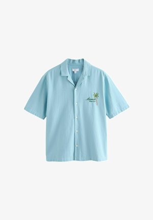 Lyseblå kortærmet skjorte med krave og brystbroderi af en palme og teksten "Morocco Blue City".