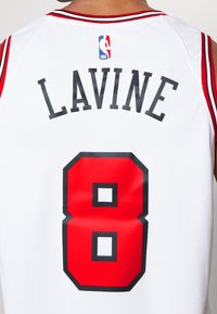 Maglia da basket bianca con dettagli rossi, scritte nere con "LAVINE" e numero "8" contornato in nero. Logo NBA sul retro.
