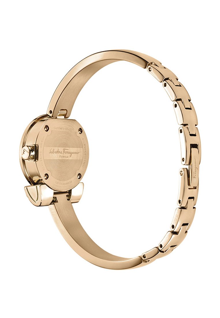 Montre en métal doré avec un cadran circulaire et un bracelet à maillons. Gravures notables au dos du boîtier et finition lisse.