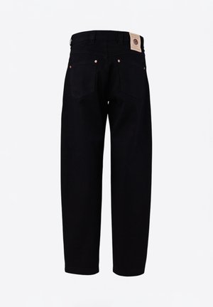 Black denim trousers featuring a loose fit, two back pockets, copper rivets, and a branded leather patch at the waistband.