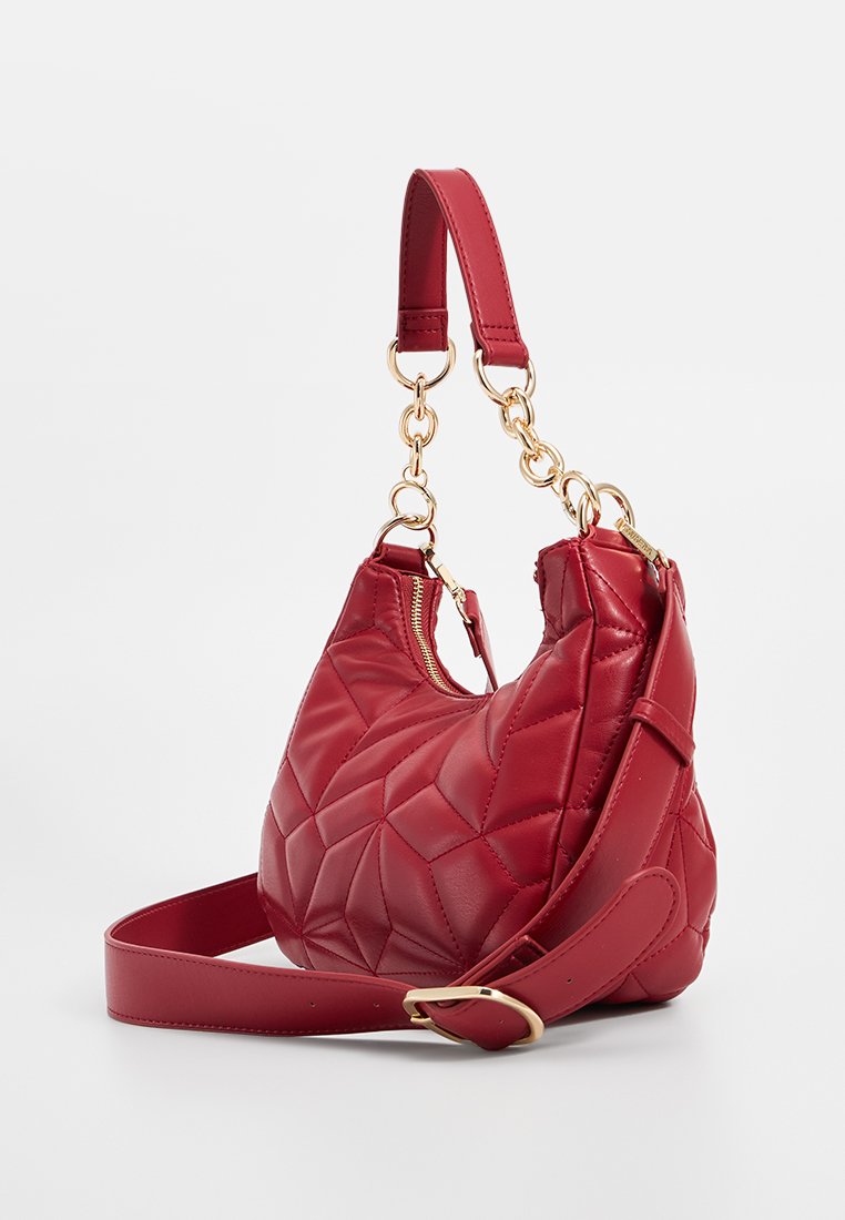 Rote gesteppte Leder-Handtasche mit goldenen Kettendetails, einem kurzen Griff, verstellbarem Schultergurt und einem Reißverschluss.